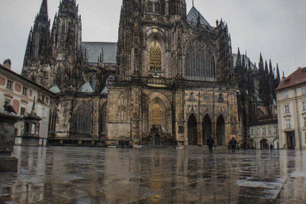 The gothic west front of a cathedral seen from a stone castle courtyard