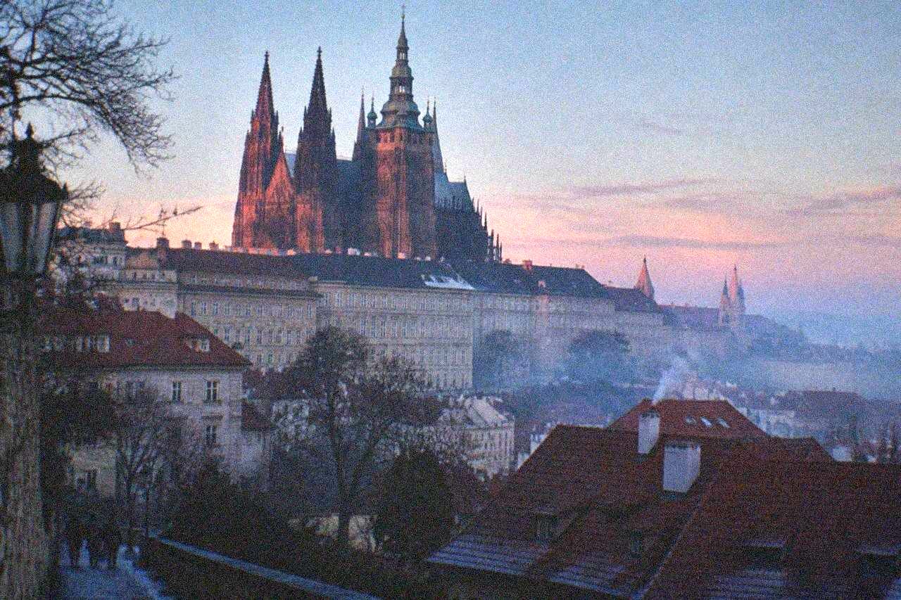 Gothic cathedral towers rising above the red rooftops of Prague Castle