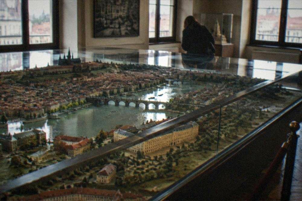 Grand museum hall with a large historic scale model of a city on display under natural light