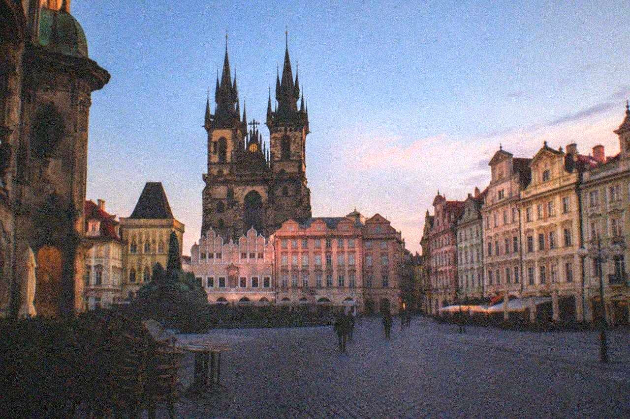 Old Town Square in Prague with the Astronomical Clock tower and colourful baroque facades under an evening sky