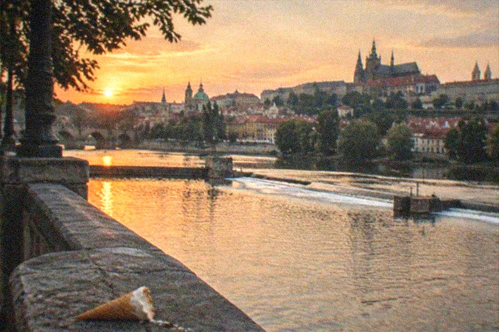 View along the Vltava from the bridge with riverbanks and rooftops on both sides