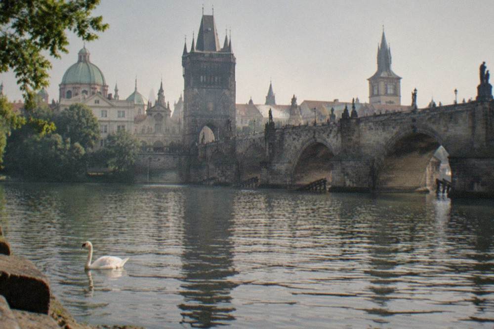 Charles Bridge crossing the Vltava with towers and domes of Prague behind it