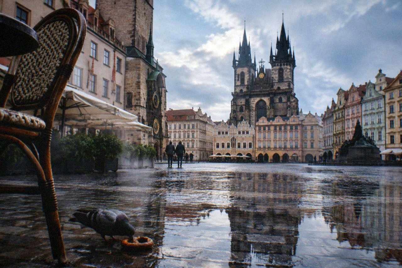 Old Town Square in Prague with historic facades and the Astronomical Clock tower under a daytime sky
