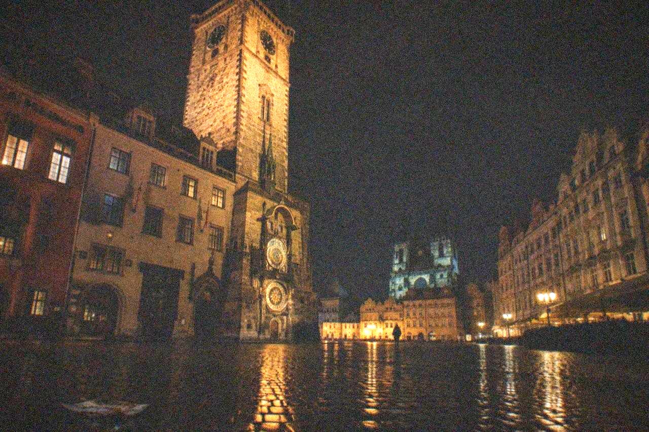 Old Town Square at night with the Old Town Hall tower above dark cobblestones