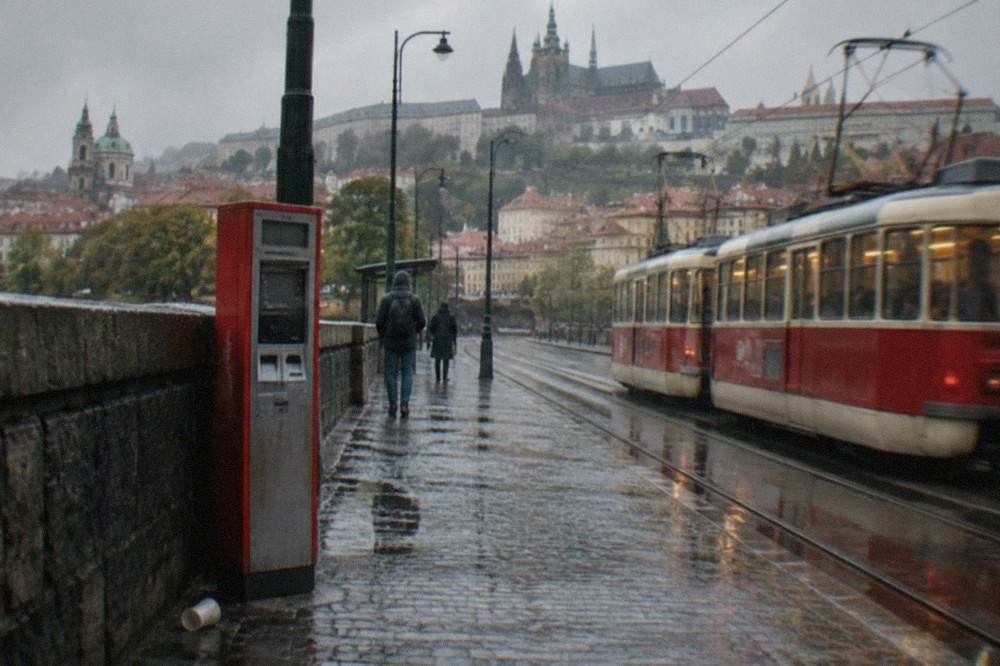 A ticket machine and tram stop shelter on a Prague street