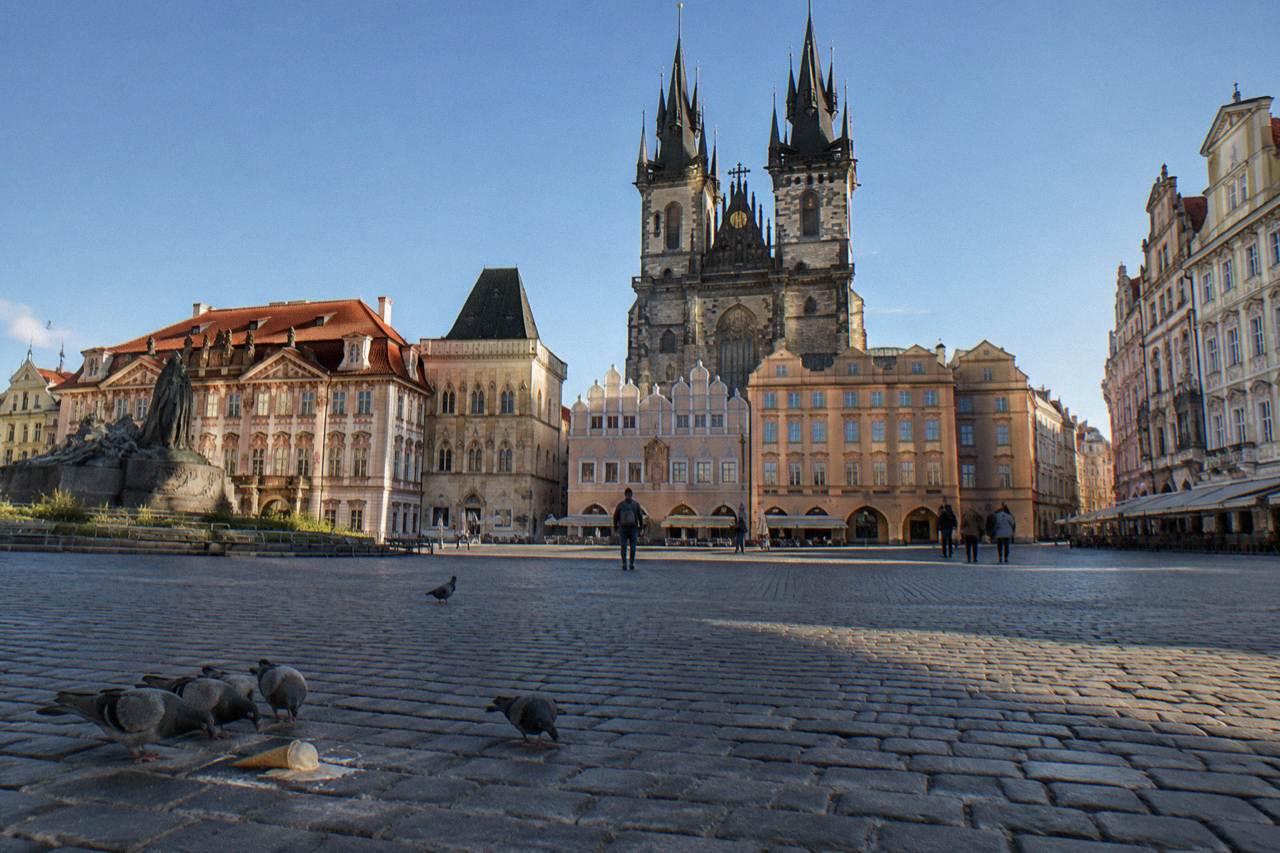 Old Town Square in Prague with the Astronomical Clock tower rising above open cobblestone space