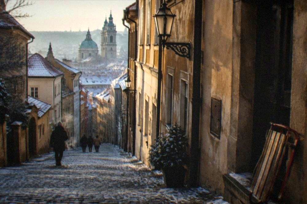 Quiet Lesser Town street with baroque facades leading uphill from the river
