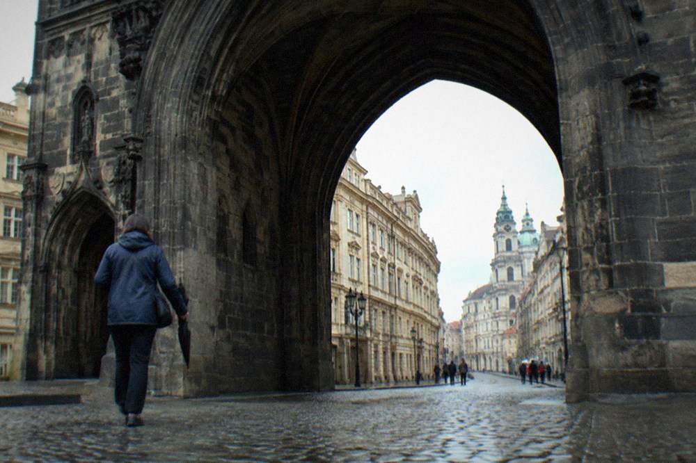 Visitors standing beneath the gothic Powder Tower arch on Celetna Street in Prague