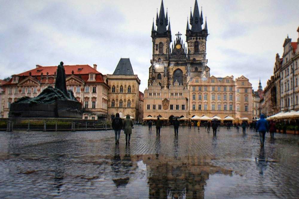 Open public square with historic facades and a tower in Prague Old Town
