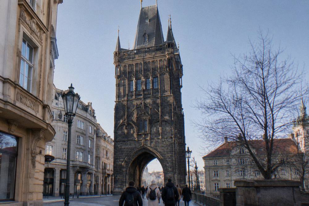 Free walking tour group gathered with a guide at the edge of Old Town Square near the Powder Tower