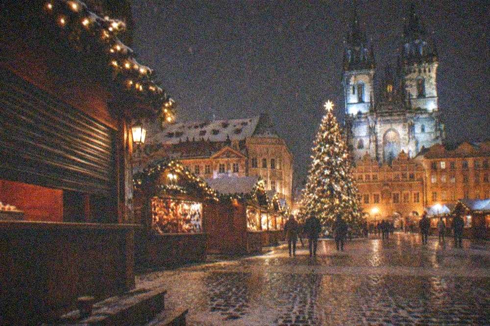 Old Town Square Christmas market stalls and illuminated tree in front of the Old Town Hall at night