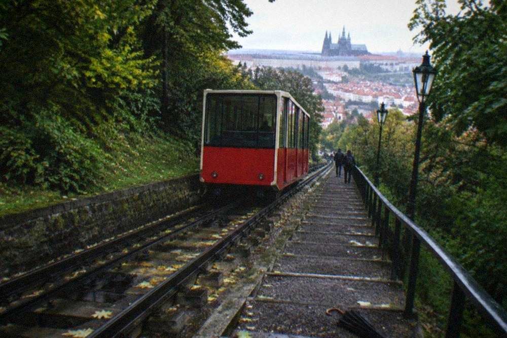 A funicular railway car on an inclined track climbing a wooded hillside