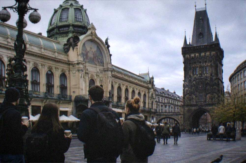 Guides and visitors gathered at a meeting point on a Prague square before a walking tour