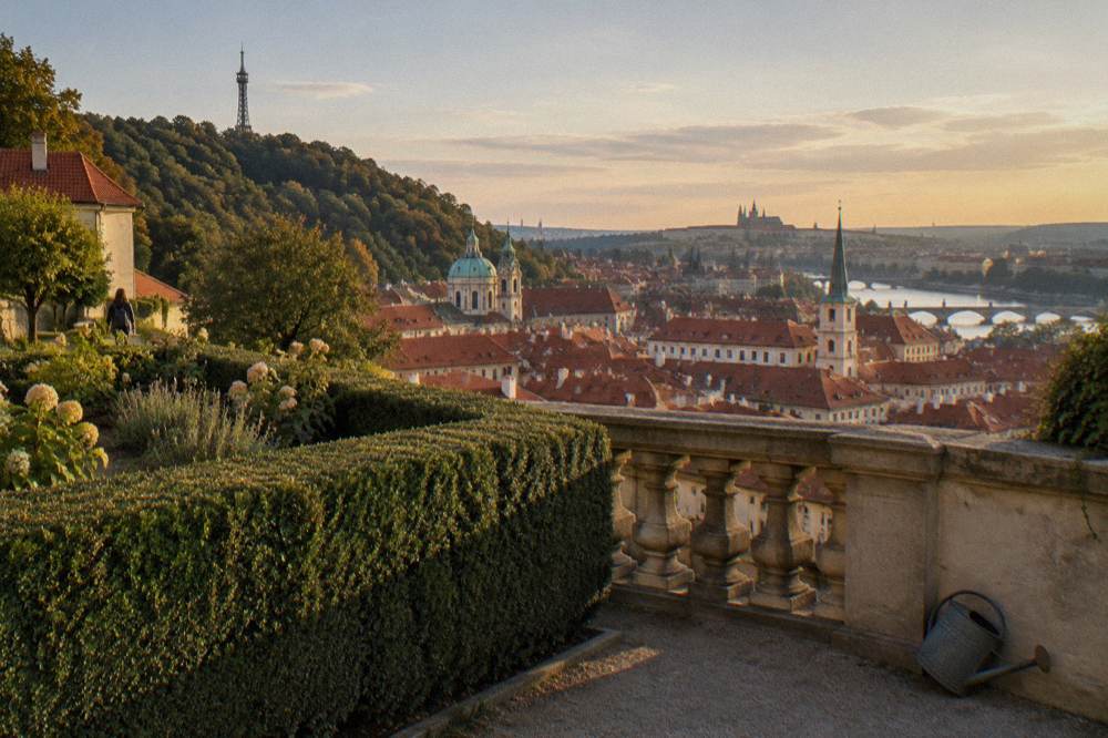 Terraced hillside park above red rooftops and the Vltava river on a warm afternoon in Prague
