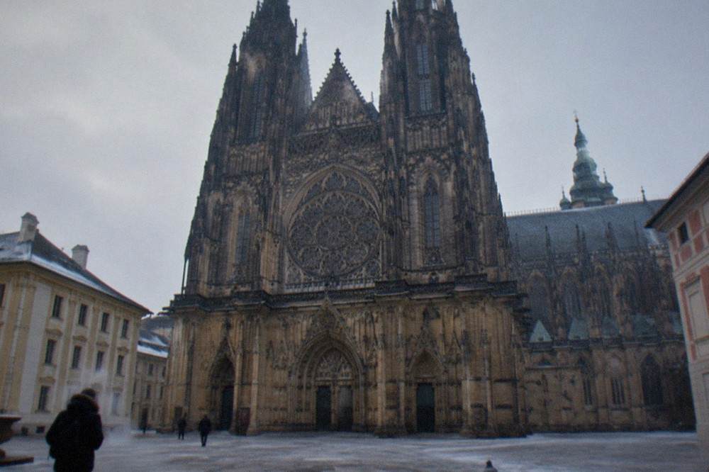 Gothic west front of a cathedral with twin towers seen from a paved courtyard